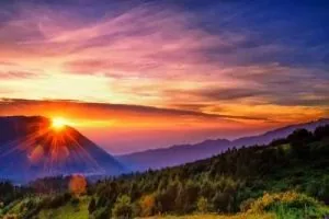 Pemandangan matahari terbit yang spektakuler di Gunung Bromo, Jawa Timur, dengan langit berwarna-warni. Waktu terbaik menikmati bromo